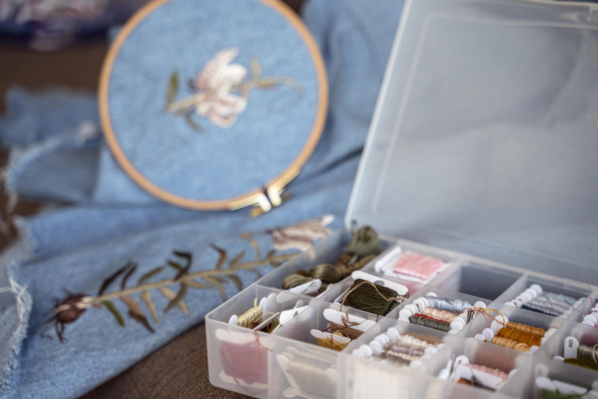 Studio workspace with embroidery frames and threads