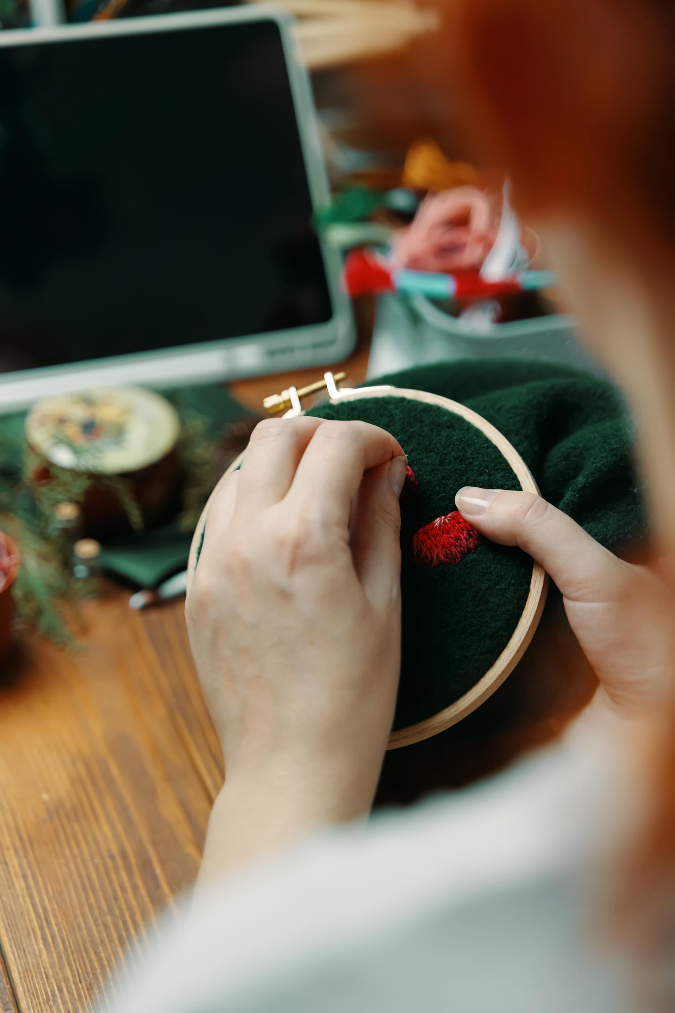 Artist hands working on embroidery frame
